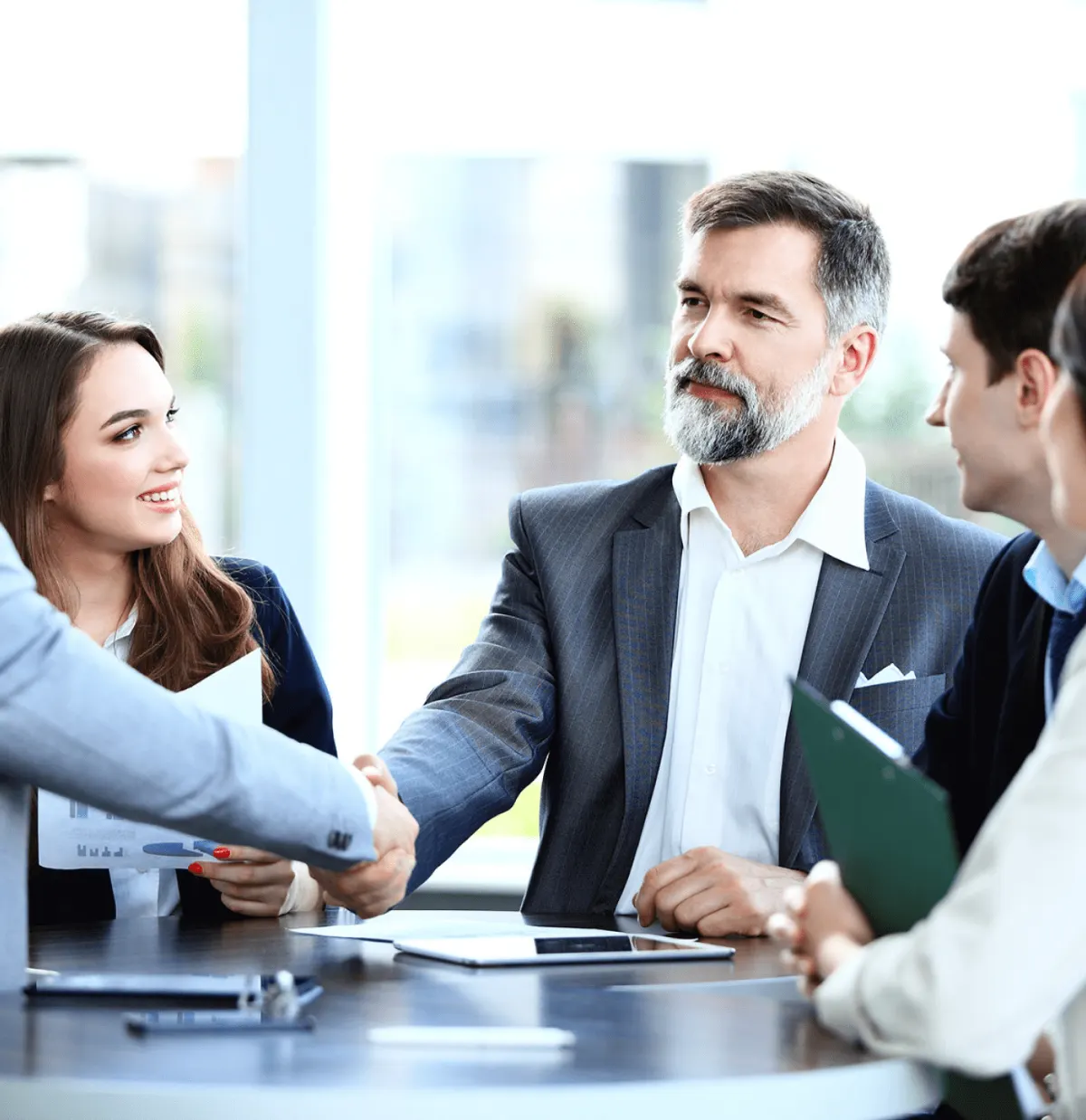 Colleagues shaking hands in a glass-walled office