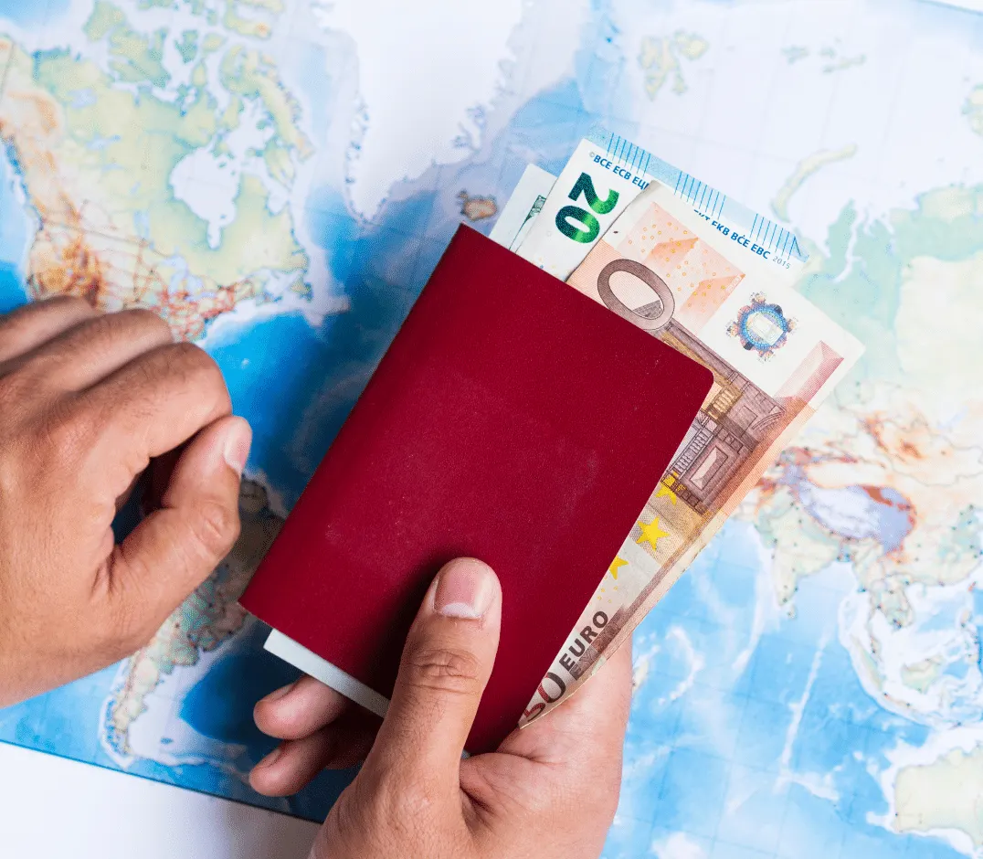 A passport and euro notes held over a world map